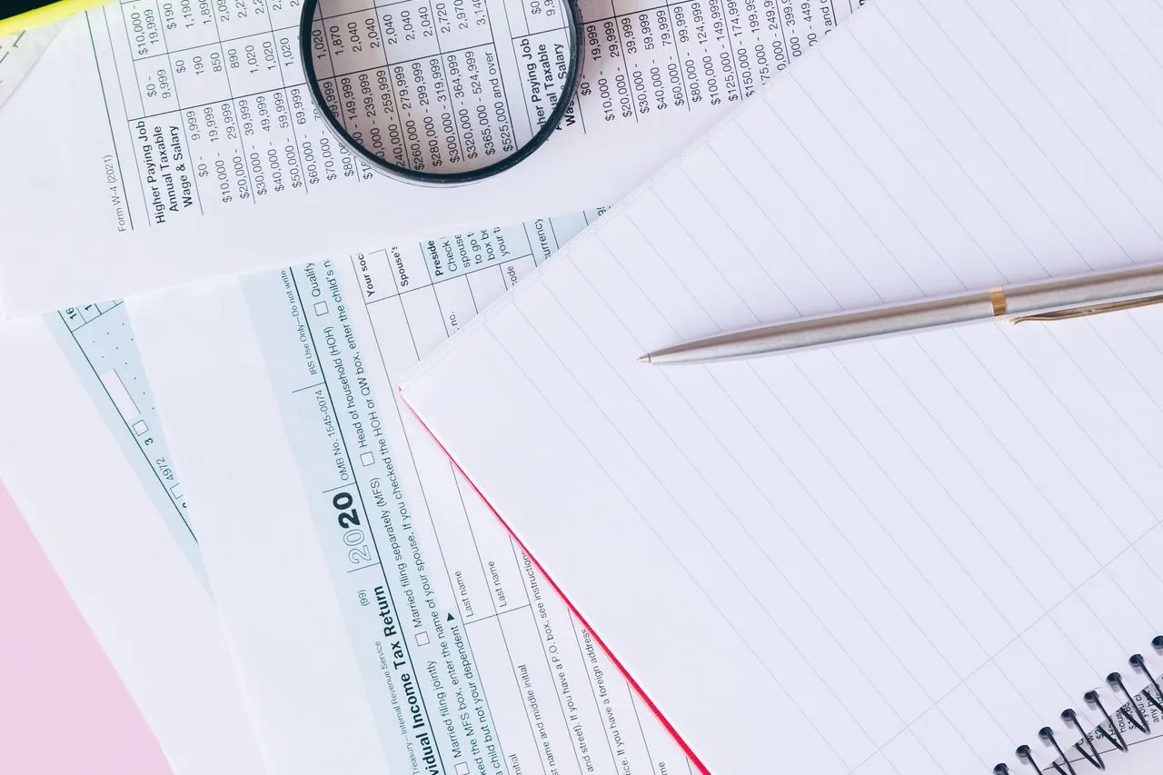 Escritorio contable con calculadora, documentos financieros y una laptop