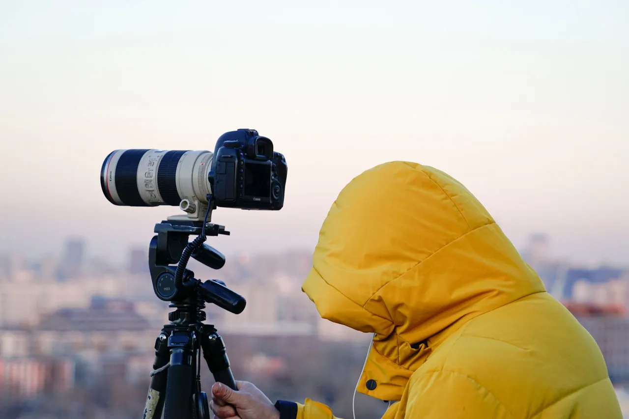 Fotógrafo con cámara y trípode fotografiando una ciudad