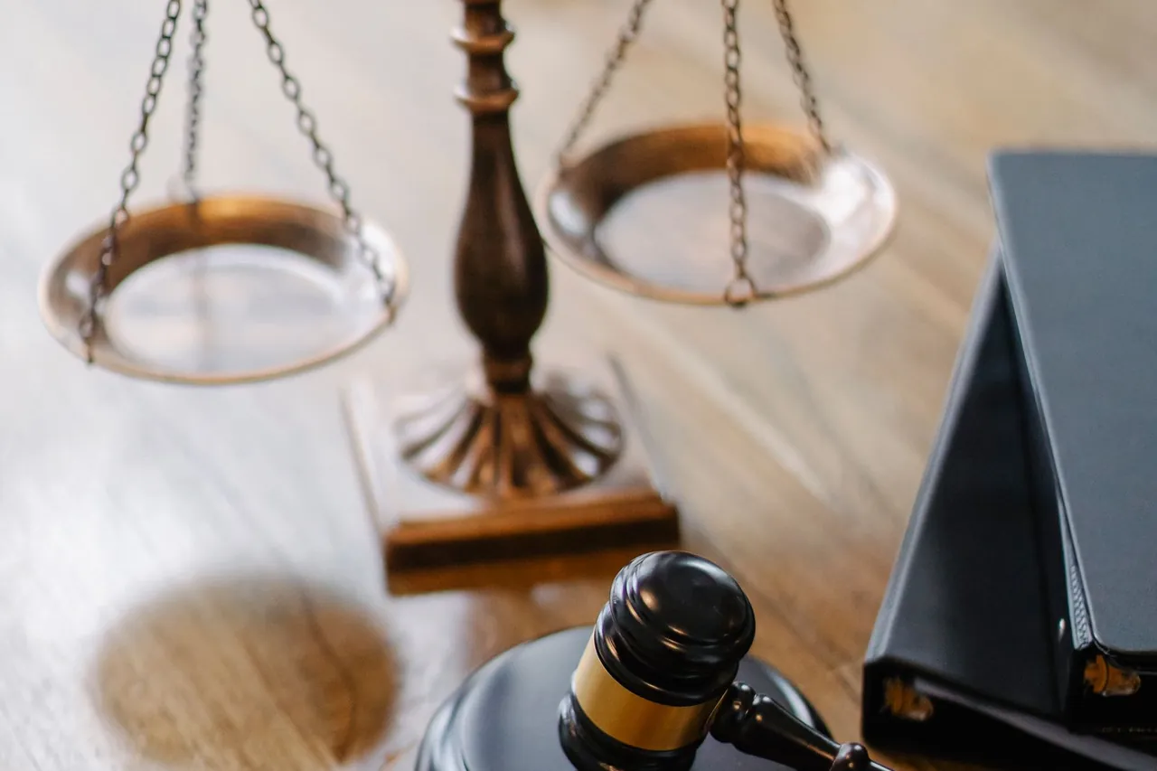 Balanza de la justicia y mazo sobre un escritorio de madera con carpetas