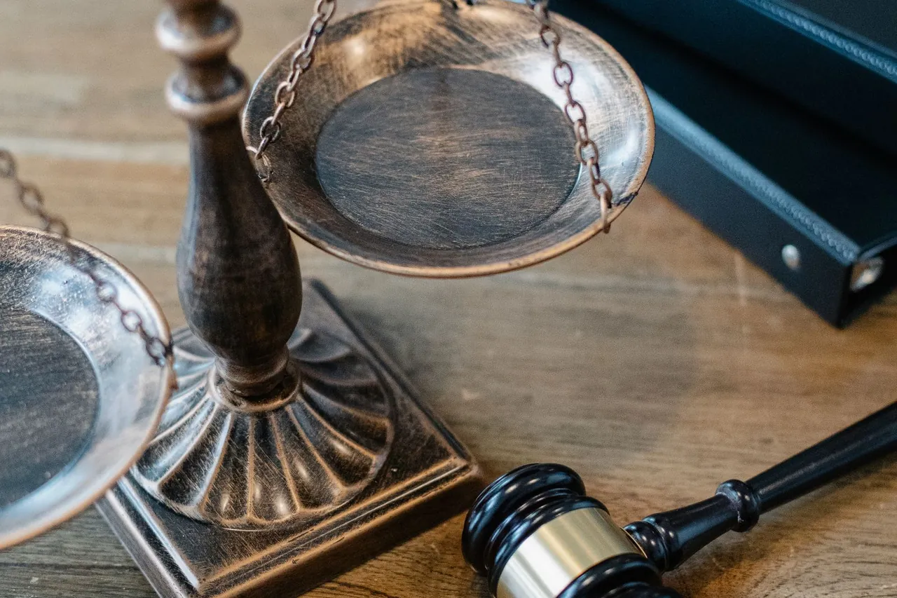 Balanza de la justicia y mazo de juez sobre una mesa de madera